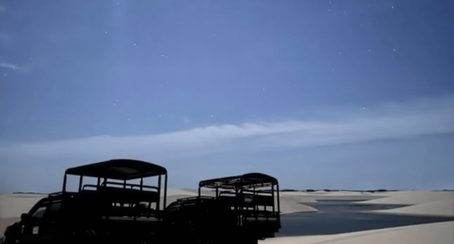 Veículos 4x4 nas dunas sob o céu noturno